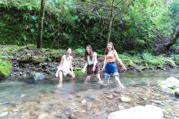 istock 3 women cooling down in cold river 1166217697