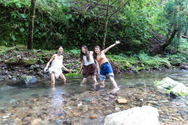 istock 3 women cooling down in cold river 1166217704