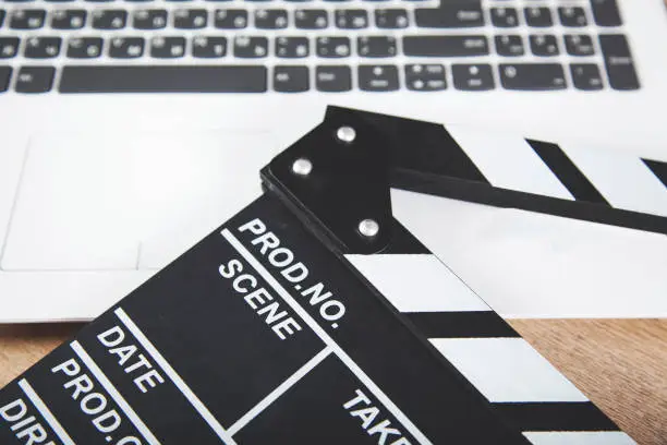 computer keyboard with movie sign on the wooden desk