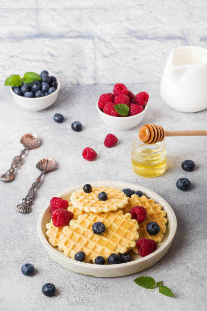 istock Corrugated waffle cookies with fresh raspberries and blueberries on a concrete background. Copy space. 1166221321