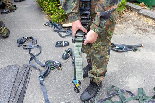 German army soldier holds a lashing ratchet