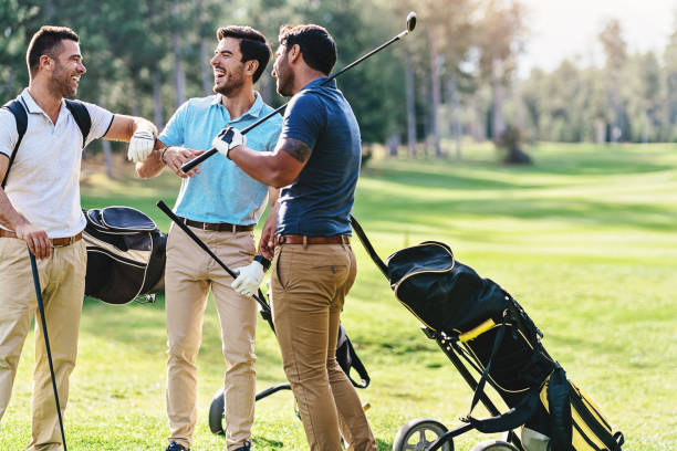 Group of golfers having good time together Multi-ethnic group of male golf players talking on the course playground male friendship stock pictures, royalty-free photos & images