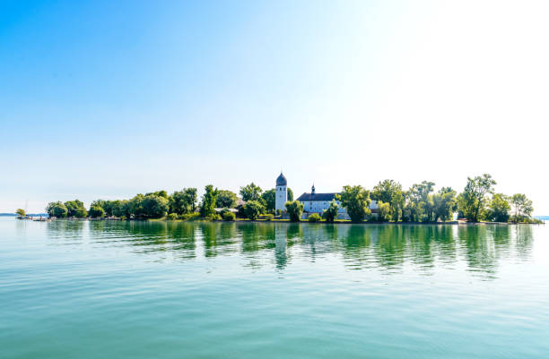 Fraueninsel, Frauenchiemsee on lake Chiemsee in the  morning sunrise with boat, Sailboat, church, monastery. Bavaria, Bayern, Germany