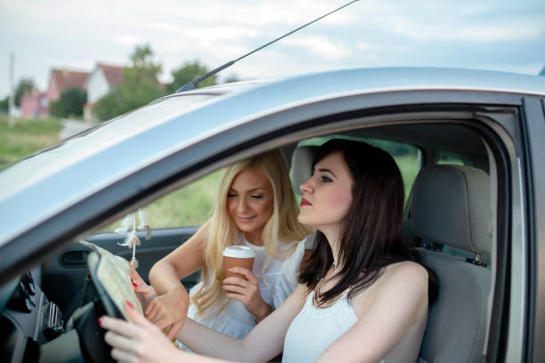 istock Young women is driving a car and looking at the map. 1166223744