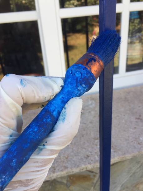 istock Hand holding a paintbrush painting a blue rail 1166225862