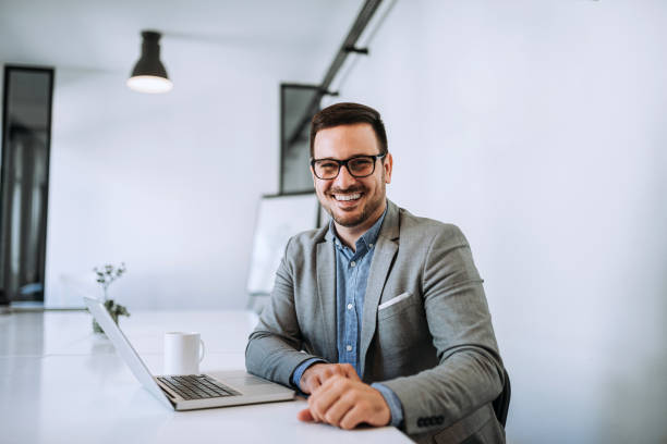 istock Young smiling entrepreneur in bright office working on laptop. 1166228245