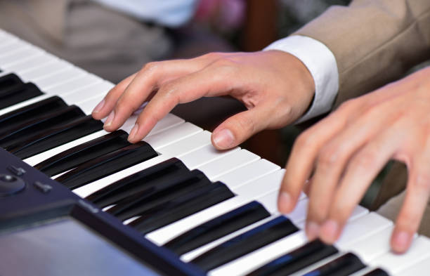 istock Close up man hand playing piano on wedding or concert 1166229159