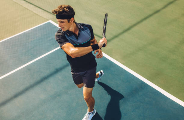 tennis player hitting powerful forehands in a game - tennis court tennis racket forehand imagens e fotografias de stock