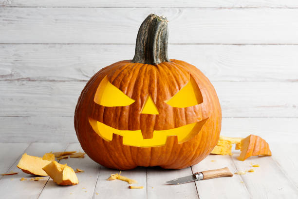 intaglio jack-o-lantern per la celebrazione di halloween - gourd halloween fall holidays and celebrations foto e immagini stock
