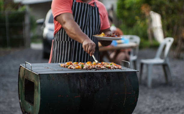 istock man doing a barbecue to celebrate with friends 1166241101