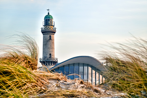 Lighthouse of Warnemünde (Germany) behind sand dunes covered with marram grass