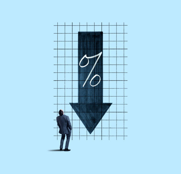A businessman places his hand on his head as he looks up and is perplexed by a chart indicating falling interest rates.