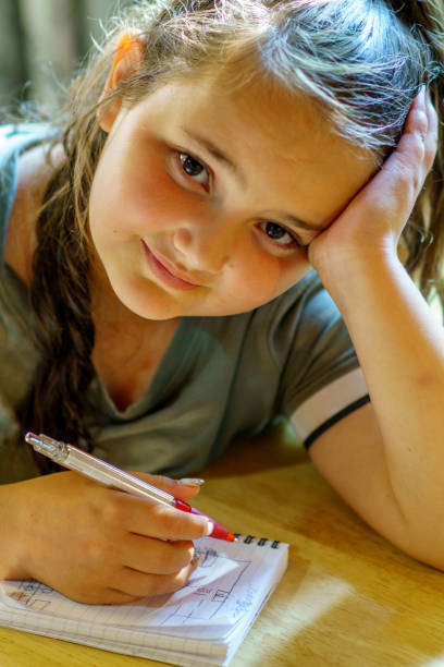 istock Eleven year old girl writing in notepad 1166250270