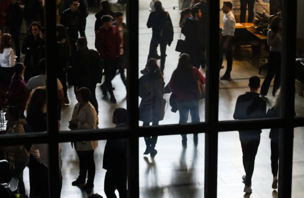 Jobs Fair in Bucharest. Bucharest, Romania - Novemder 07, 2018: The silhouettes of students are seen through a window at a job fair in Bucharest. This image is for editorial use only. job fair photos stock pictures, royalty-free photos & images