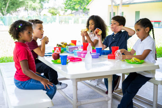 istock Elementary aged Hispanic schoolchildren outdoors for lunch 1166252054