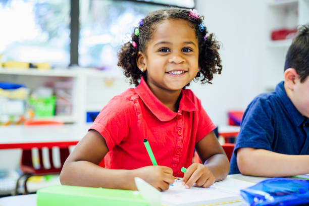 istock Smiling Hispanic schoolgirl drawing in the classroom 1166252127
