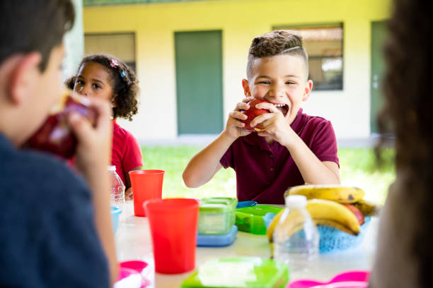 istock Hungry elementary aged Hispanic schoolboy eating an apple 1166252217
