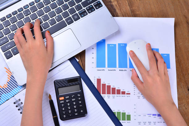 istock Hand on keyboard and mouse with graph, chart on wooden table 1166252326