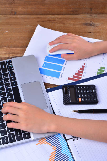 istock Hand on keyboard and mouse with graph, chart on wooden table 1166252439