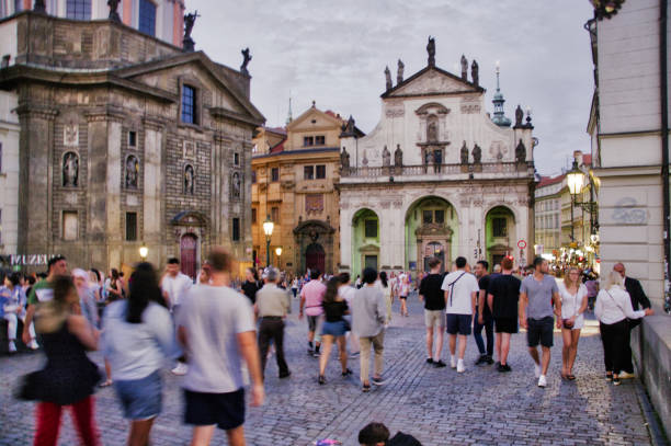Charles Bridge Prague Czech republic, July 22 2019, tourists crossing the historic Charles Bridge in the old town in the city center at about 9pm on a warn summer evening