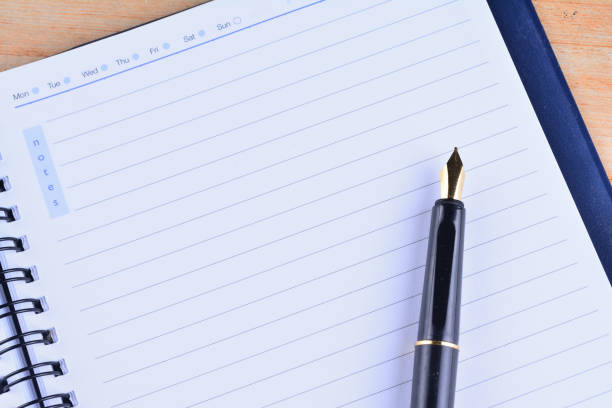 istock Notebook with fountain pen on wooden table 1166254322