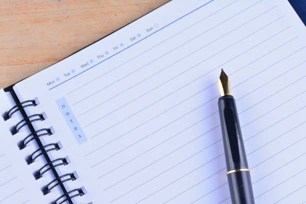 istock Notebook with fountain pen on wooden table 1166254371