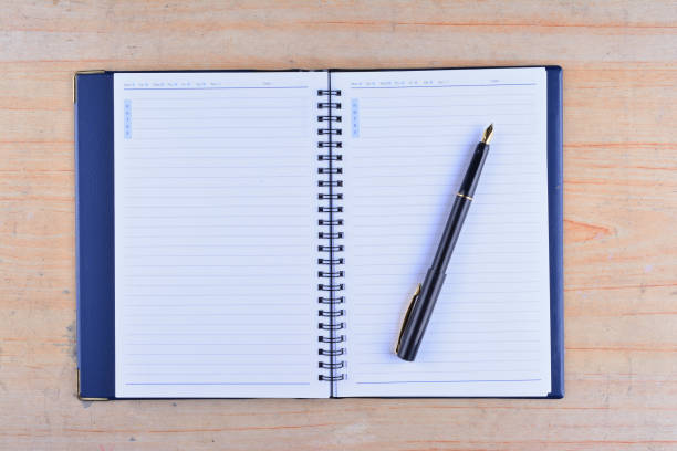 istock Notebook with fountain pen on wooden table 1166254395