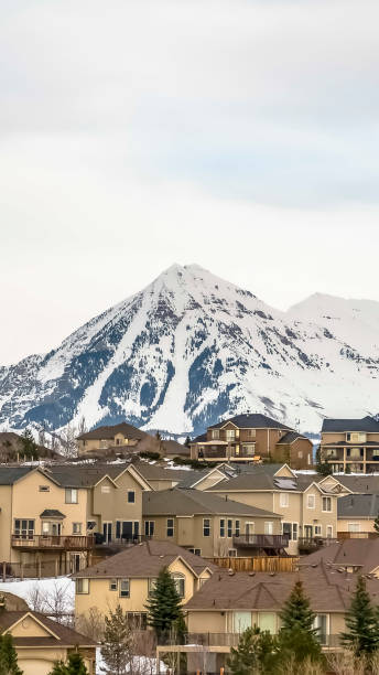 istock Vertical frame Hill homes with rugged snow covered mountain peak in the background 1166257757