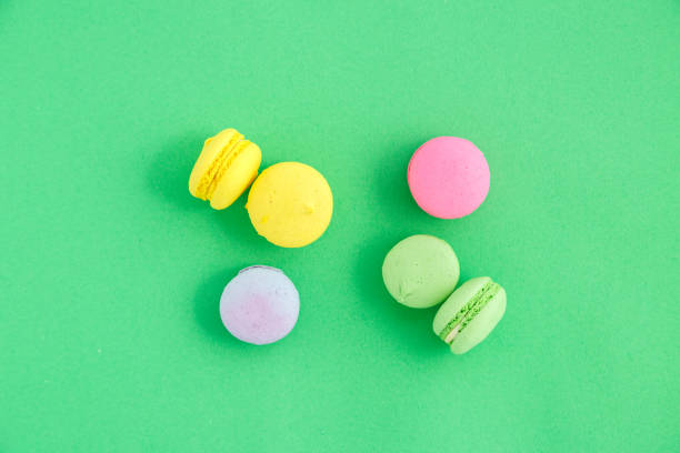 istock colorful macarons or macaroons cookies on green background. top view 1166257764