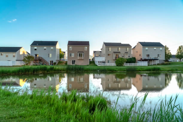 istock Houses reflected on a shiny pond with blue sky overhead on a sunny day 1166257795