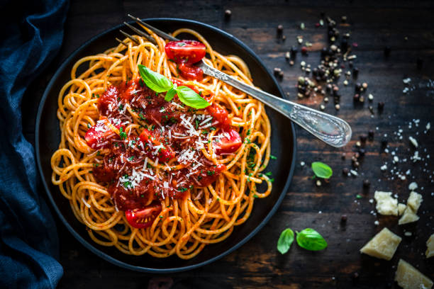 Spaghetti with tomato sauce shot on rustic wooden table