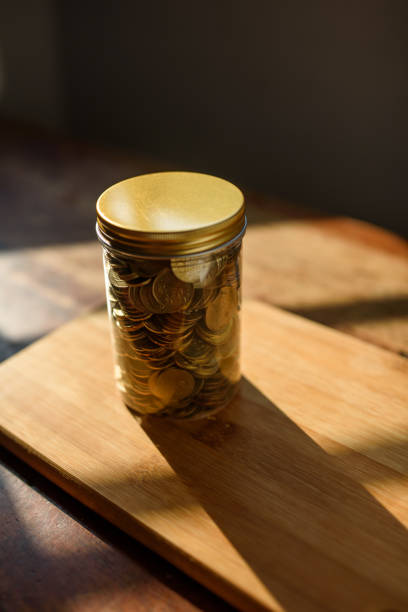 coins in glass jar - coin cheap jar currency imagens e fotografias de stock