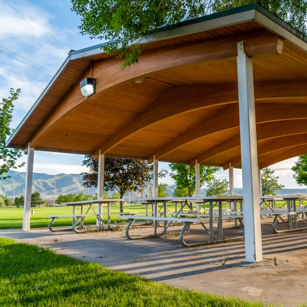 istock Square frame Picnic tables and benches under a pavilion on a scenic park on a sunny day 1166258873