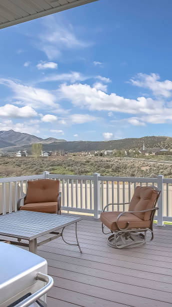 istock Vertical frame Table chairs and barbecue grill on the home balcony with white wooden railing 1166258913