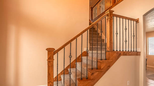istock Panorama frame Carpeted stairs with wood handrail and metal railing inside an empty new home 1166258980