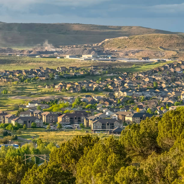 istock Square frame Residential area on a valley with view of distant mountain and cloudy blue sky 1166259744