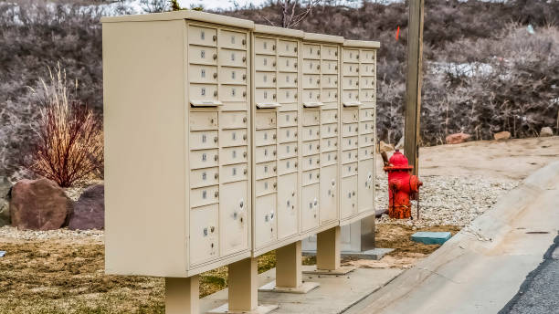 istock Panorama White metal cluster mailboxes and red fire hydrant along a concrete road 1166259833