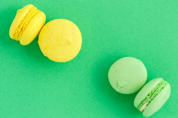 istock colorful macarons or macaroons cookies on green background. top view 1166260442