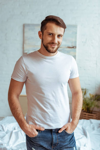 istock good-looking man in white t-shirt with hands in pockets looking at camera 1166261473