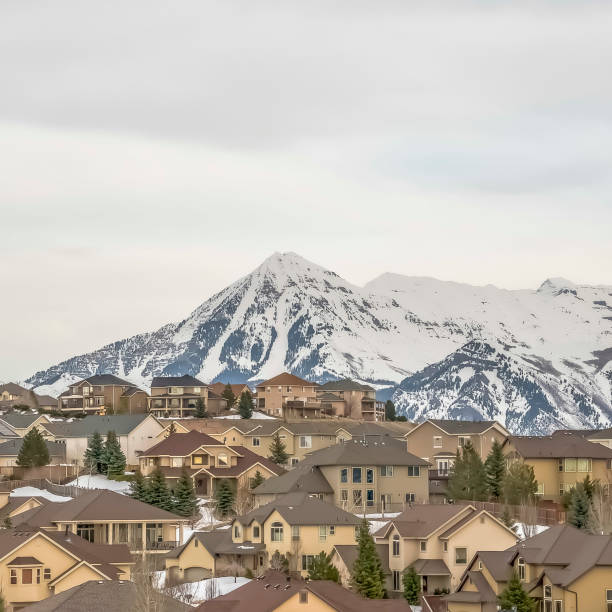 istock Square frame Residences and towering mountain under bright cloudy sky viewed in winter 1166261661