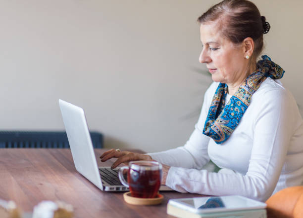 istock Senior Woman uses a laptop 1166263350