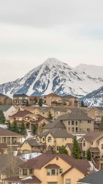 istock Vertical frame Residences and towering mountain under bright cloudy sky viewed in winter 1166263540