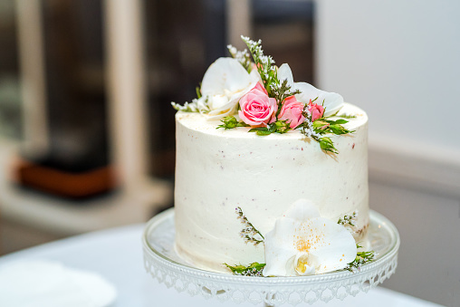 White cream wedding cake with flower decoration on it.