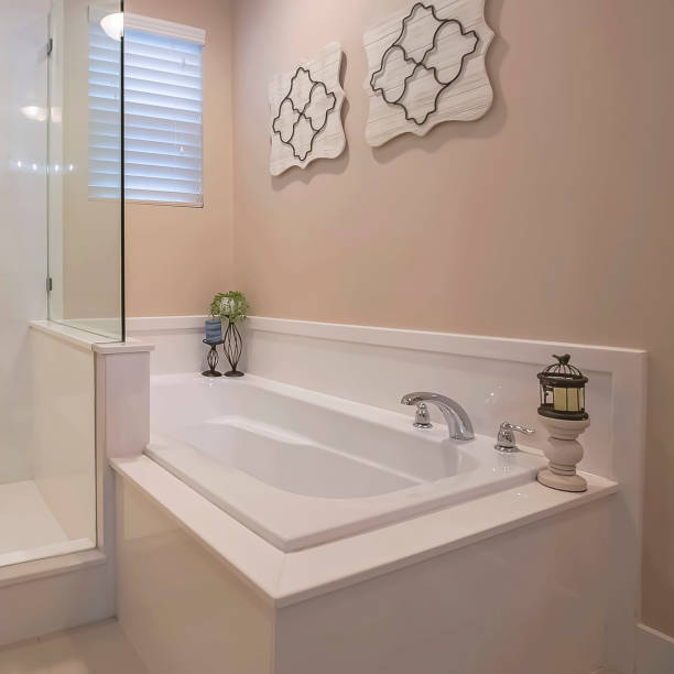 istock Square Bathroom interior with a polished built in bathtub and shower stall 1166264281