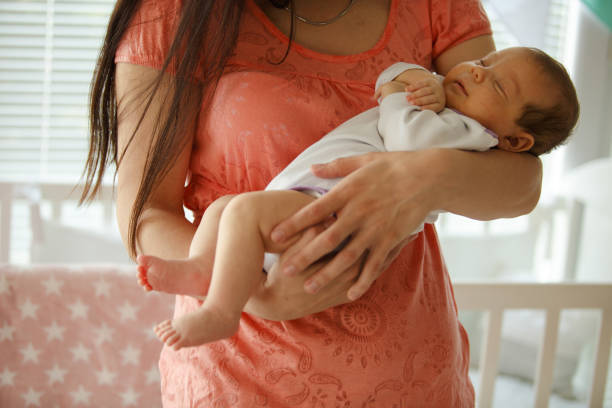 istock Baby sleeping in mother's arms 1166264291