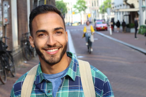 guapo joven étnico joven sonriendo al aire libre - chilean ethnicity fotografías e imágenes de stock