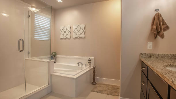 istock Panorama frame Bathroom interior with a shower stall beside the built in bathtub 1166264955