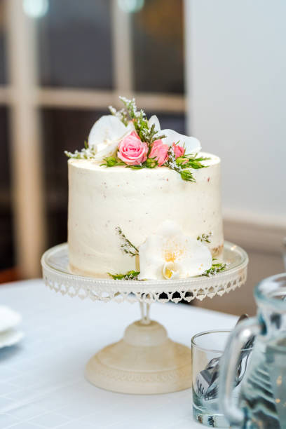 White cream wedding cake with flower decoration on it. stock photo