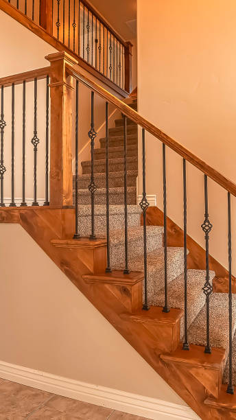 istock Vertical frame Carpeted stairs with wood handrail and metal railing inside an empty new home 1166265059
