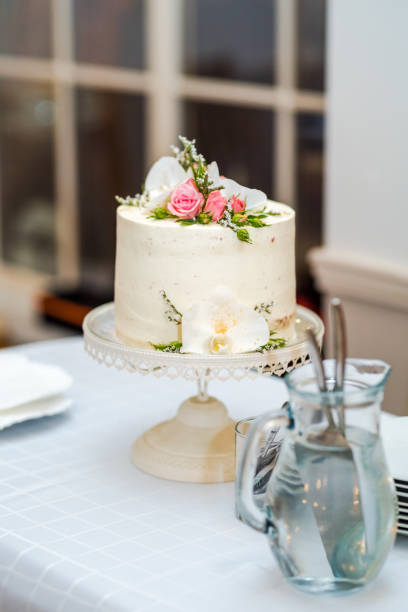 istock White cream wedding cake with flower decoration on it. 1166265227